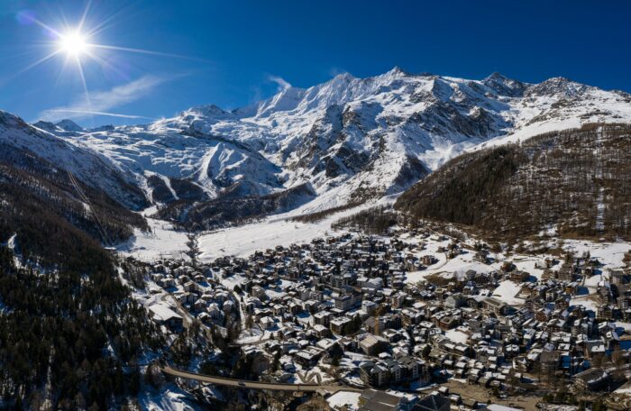 Aerial panorama of the famous Saas Fee village and ski resort by the Dom mountain, the tallest entirely in Switzerland in the alps on a sunny winter d